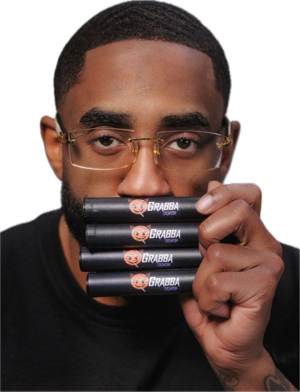 Hand holding a black Grabba Demon pre-roll tube featuring the cartoon demon logo and bold white text branding.